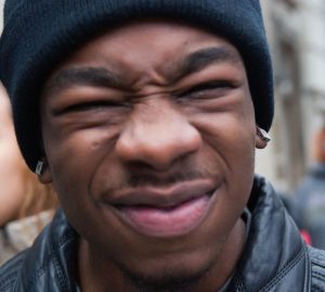 A man displays a common expression of disgust - wrinkled nose, lowered brows, narrowed eyes, raised cheeks, and curled upper lip." title="A man displays a common expression of disgust - wrinkled nose, lowered brows, narrowed eyes, raised cheeks, and curled upper lip.