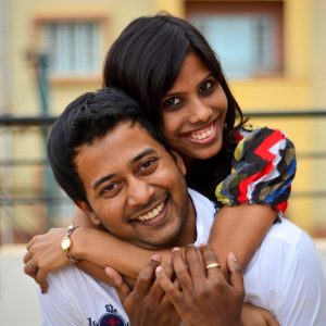 A happy couple embrace and smile broadly." title="A happy couple embrace and smile broadly.