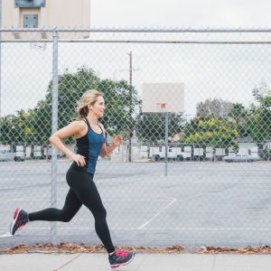 A woman jogs along the sidewalk." title="A woman jogs along the sidewalk..