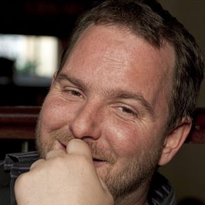 A European_American man shows a warm smile.