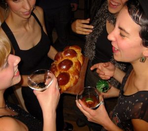 Guests at a cocktail party stand close together during a conversation.