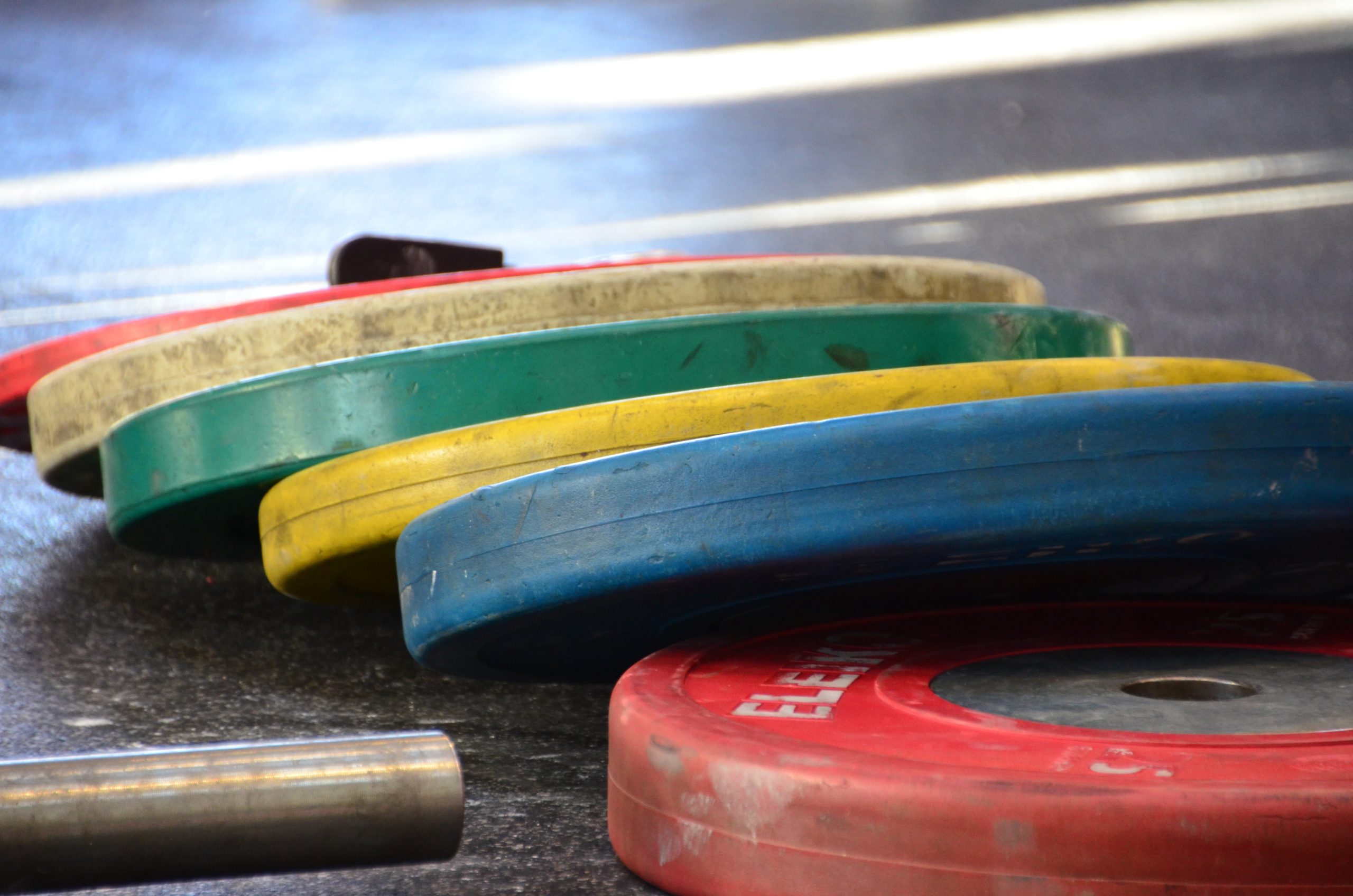 Colorful weight discs laying on the ground.