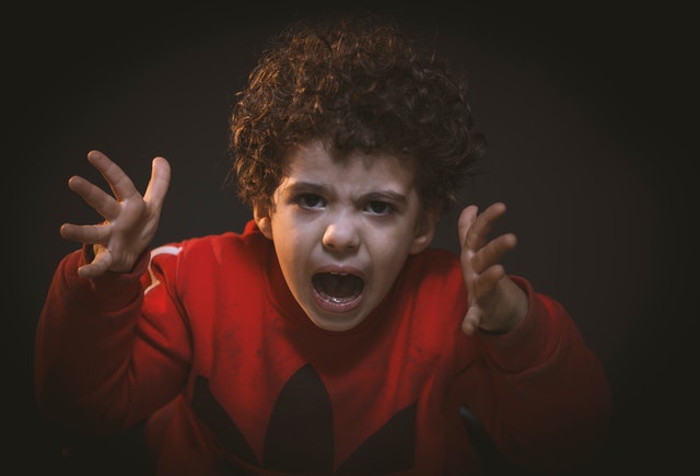 An angry child with arms outstretched