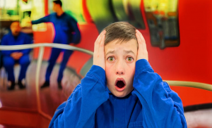 a boy with his hands on his face and mouth opened in a shocked expression