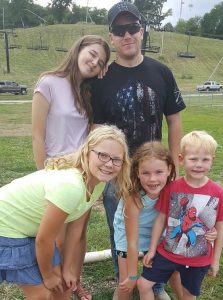 A photo of five children of different ages
