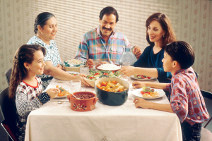 photo of a family sitting at the table eating dinner together
