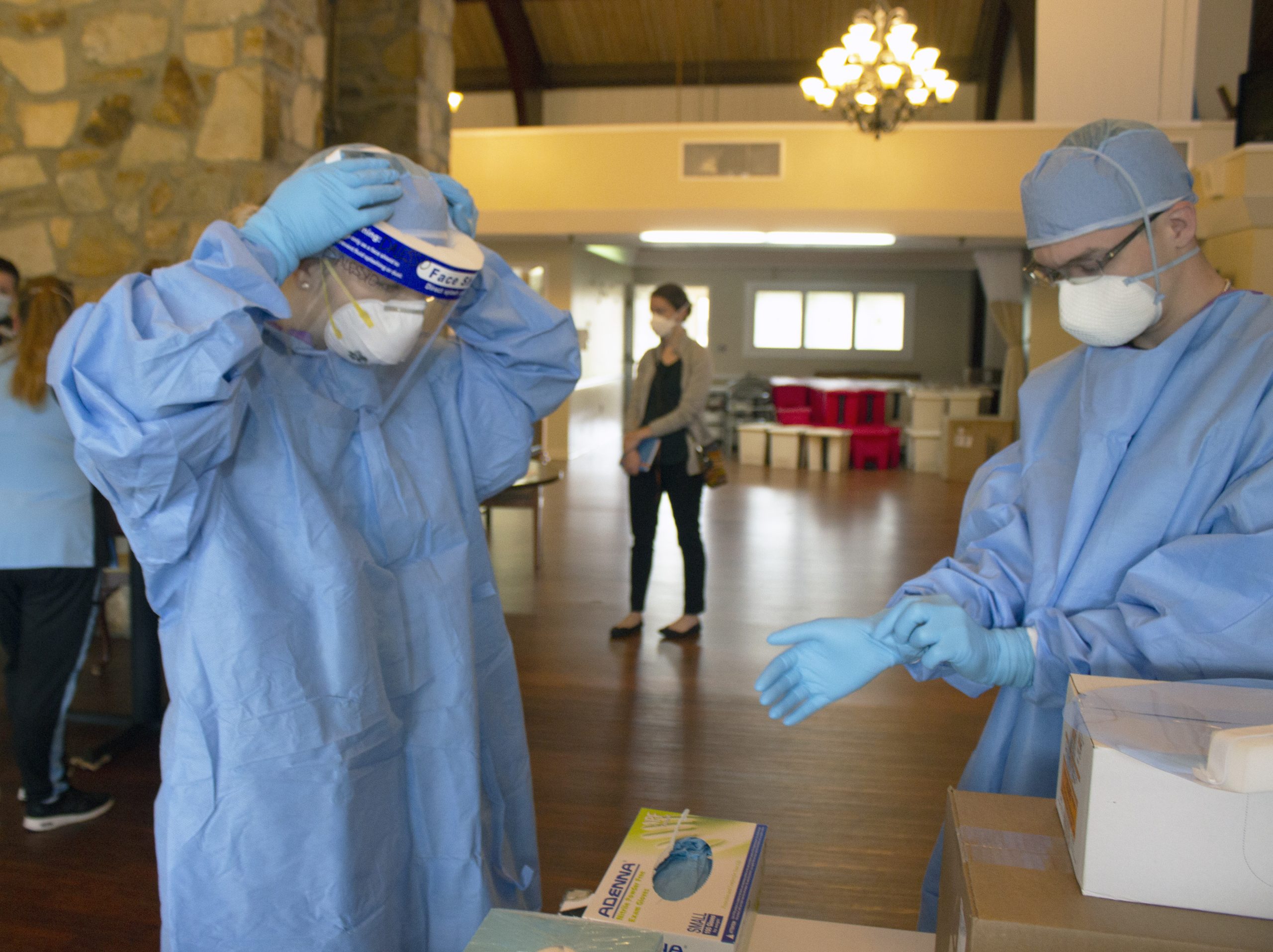 “Pennsylvania_National_Guard_(49923831732).jpg” by The National Guard is in the Public Domain. Photo of two people putting on personal protective equipment