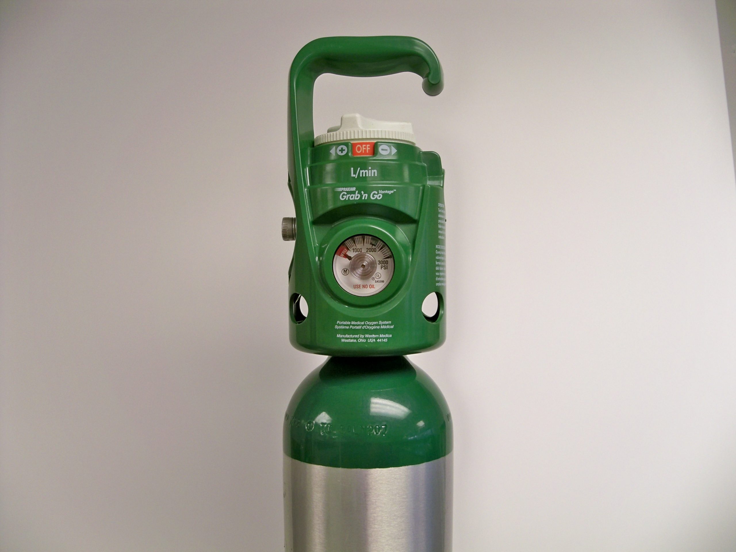 “RECALLED_–_Portable_oxygen_cylinder_units_(8294127015).jpg” by The U.S. Food and Drug Administration is in the Public Domain Photo showing the top of a portable oxygen tank