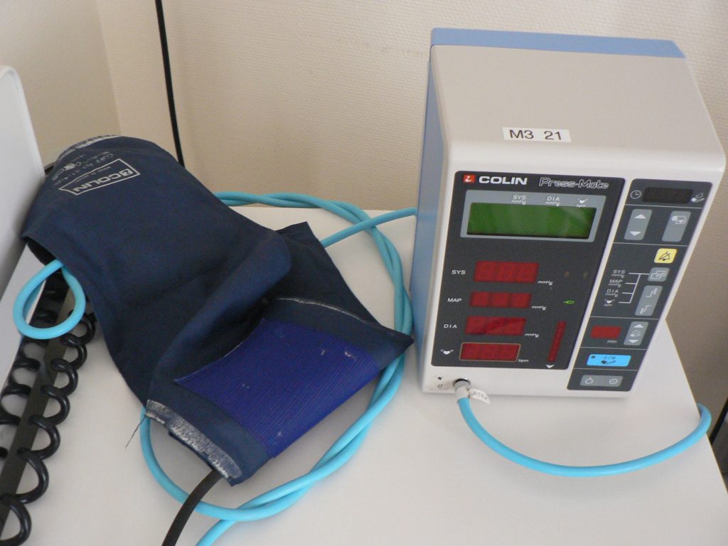 “Automatische bloeddrukmeter (0).jpg” by Harmid is in the Public Domain Photo of an automatic blood pressure monitor