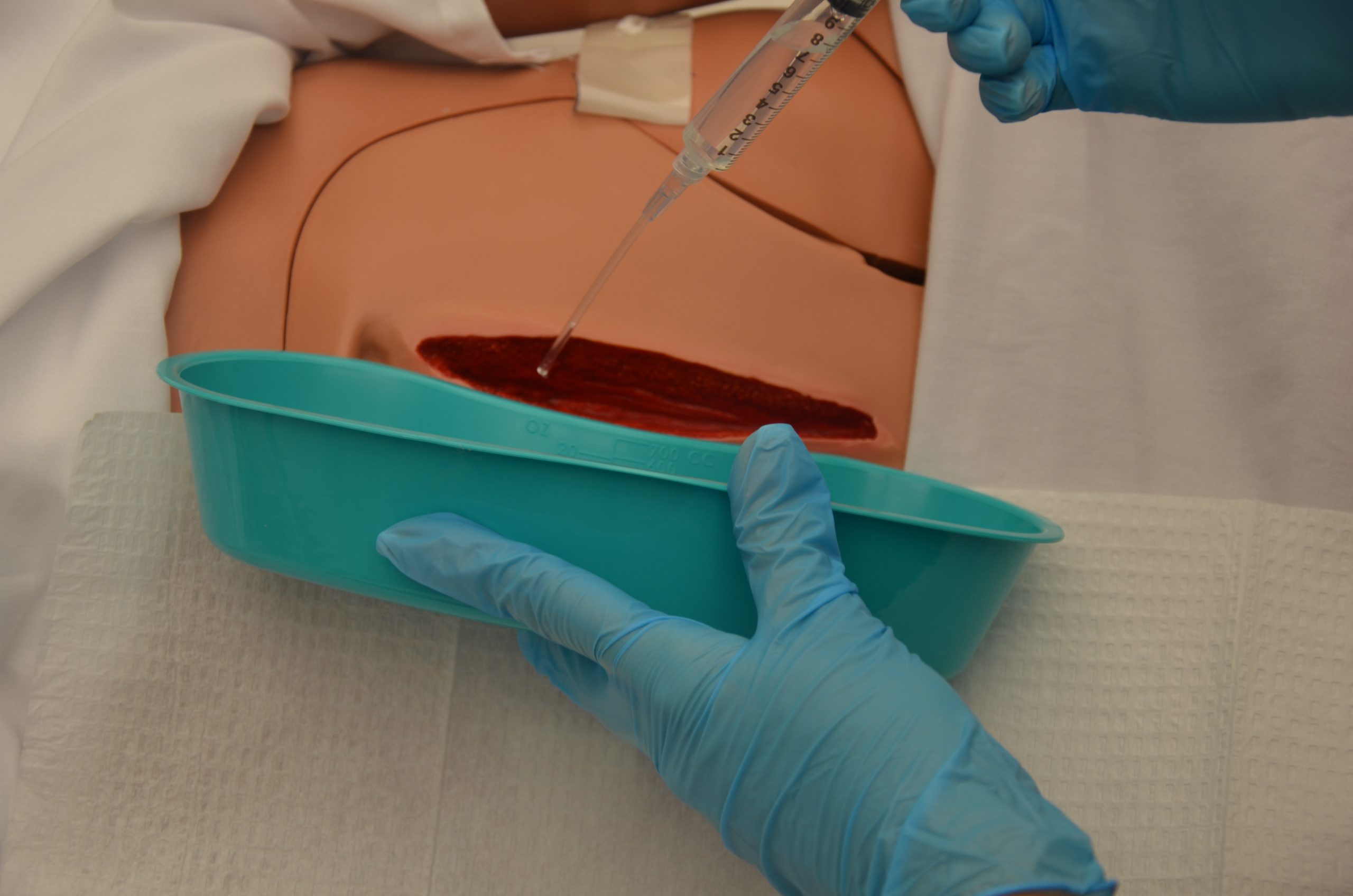 “DSC_1732.jpg” by British Columbia Institute of Technology (BCIT) is licensed under CC BY 4.0. Access for free at https://ecampusontario.pressbooks.pub/clinicalskills/chapter/4-5-complex-dressing-change/ Photo showing irrigation of simulated wound