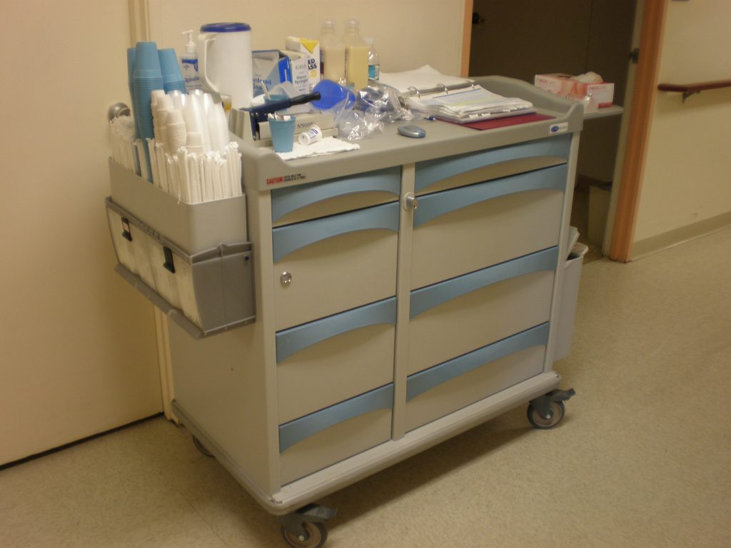 “MMI medication cart.JPG” by BrokenSphere is licensed under CC BY-SA 3.0 Photo showing medication cart