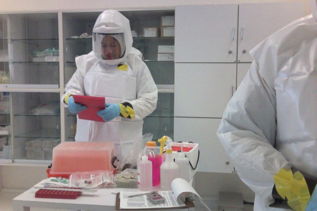 PAPRs_in_use_01.jpg by Ca.garcia.s is licensed under CC BY-SA 4.0 Image showing working wearing Powered Air Purifying Respirator in lab environment