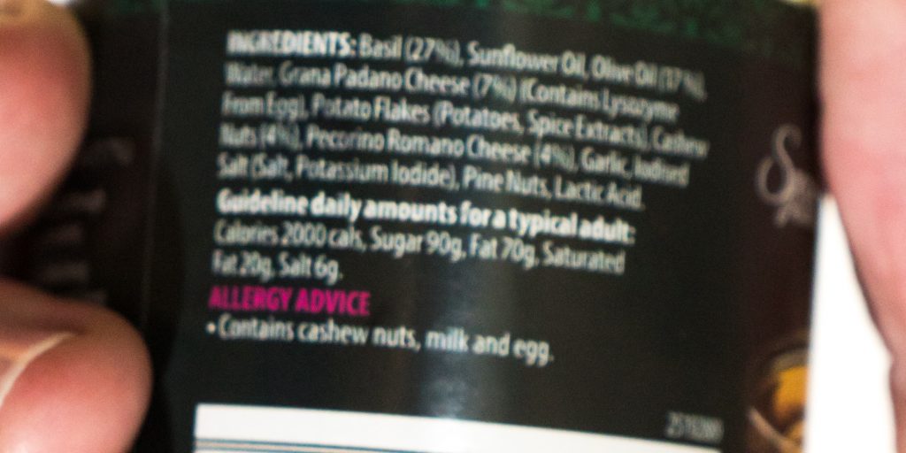 “Pesto ingredients - blurred.jpg” by Colin is licensed under CC BY-SA 4.0 Photo showing Small print. Illustrative of the problems with presbyopia.