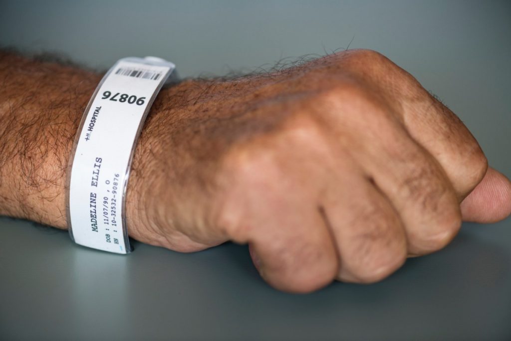 “barcode_clinic_fist_hand_healthcare_hospital_identification_identity-1517387.jpg” by rawpixel.com is licensed under CC0 Photo of hand with patient identification bracelet on wrist