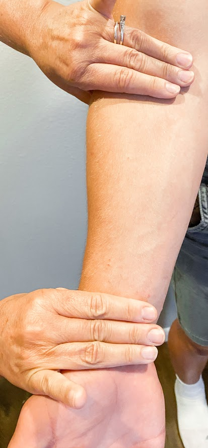 “Untitled image” Meredith Pomietlo for Chippewa Valley Technical College is licensed under CC BY 4.0 Photo showing closeup of patient's arm with nurses fingers placed at wrist and elbow.