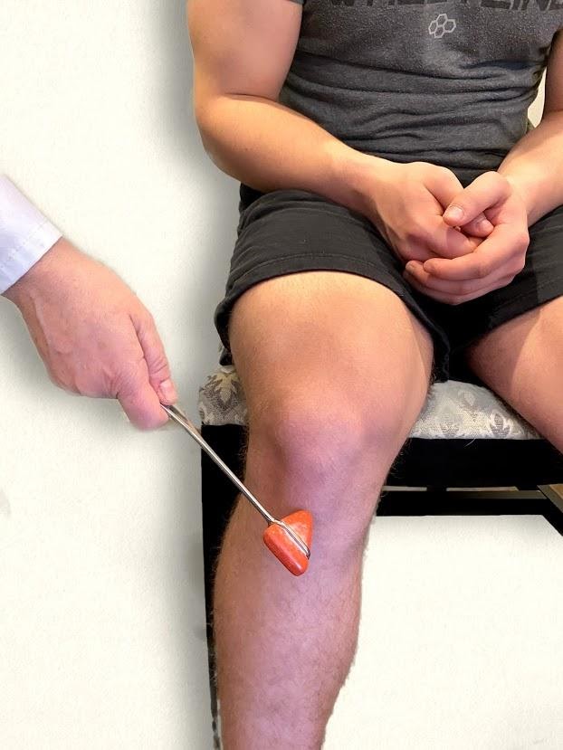 "Deep Reflex Exam image 3.jpg" by Meredith Pomietlo for Chippewa Valley Technical College is licensed under CC BY 4.0 Photo showing a nurse testing the patellar reflex