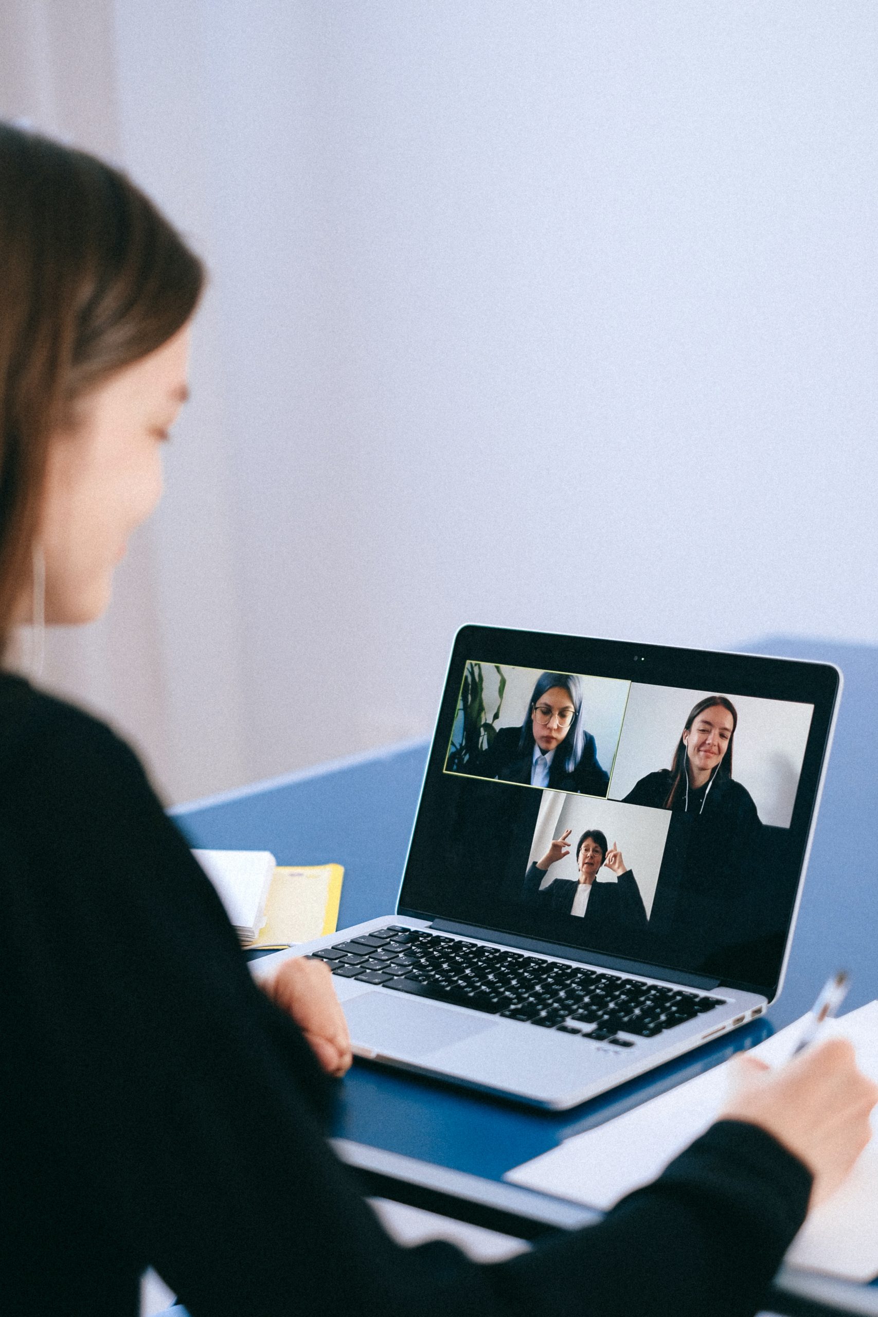 Woman on laptop videoconfrencing with others