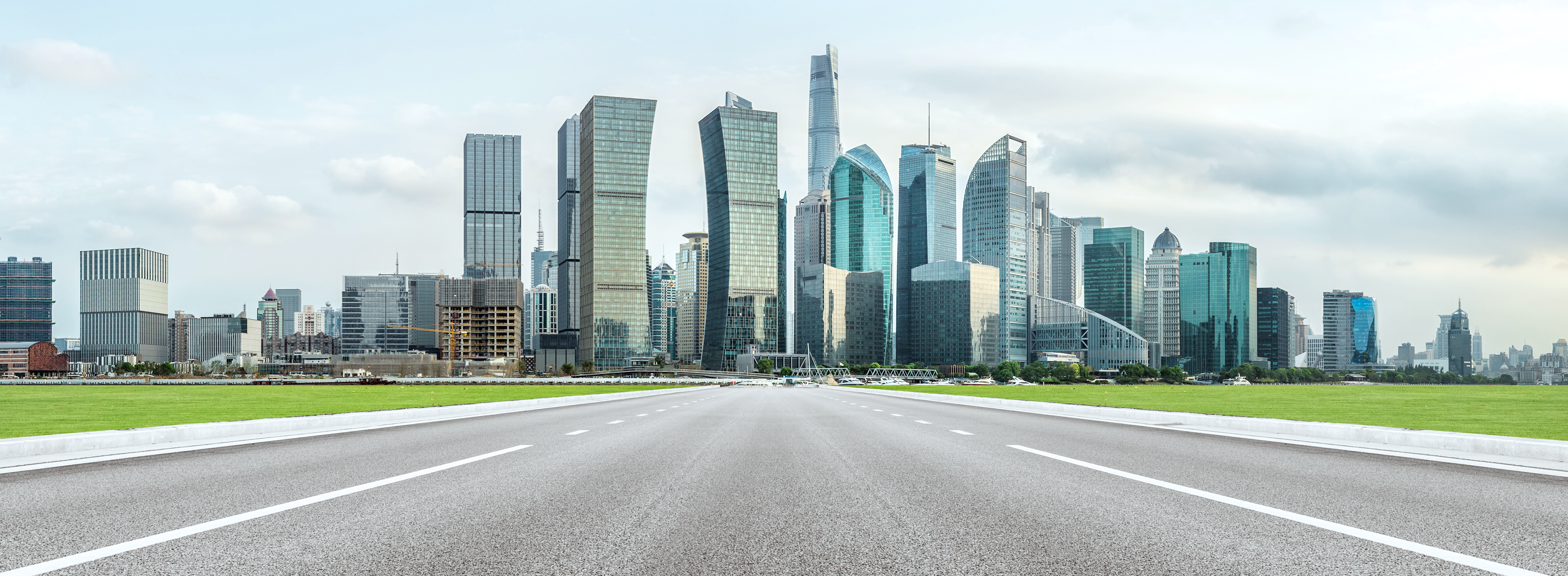 road leading towards a city skyline