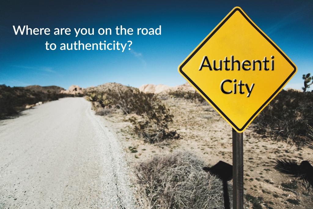 sign next to a desert road that reads Authenti City