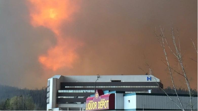 The Northern Lights Health Facility in Fort McMurray can be seen in this photo as flames shoot into the sky.
