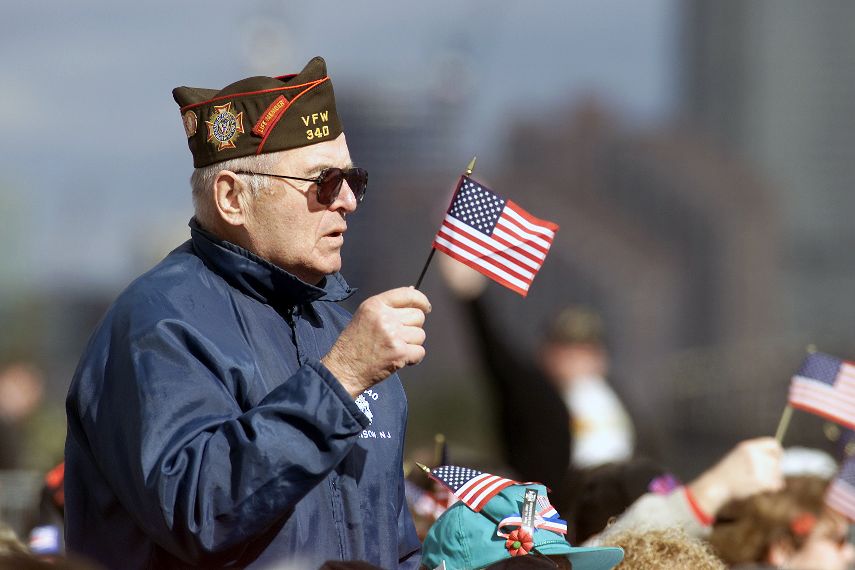 ”DF-SD-03-05175” by Scott H. Spitzer, Civilian, USAF is in the Public Domain. Photo showing an Armed Forces Veteran holding a small handheld American flag