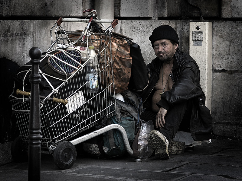 ”HomelessParis_7032101.jpg” by Eric Pouhier is licensed under CC BY-SA 2.5 Photo showing a homeless person with their belongings in a cart