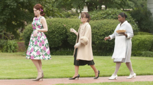 three women walking down a sidewalk